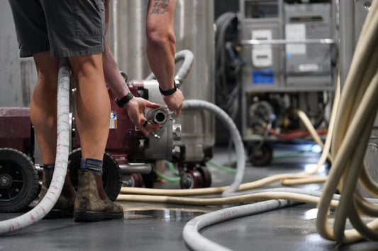 Winemaker setting up pump in winery